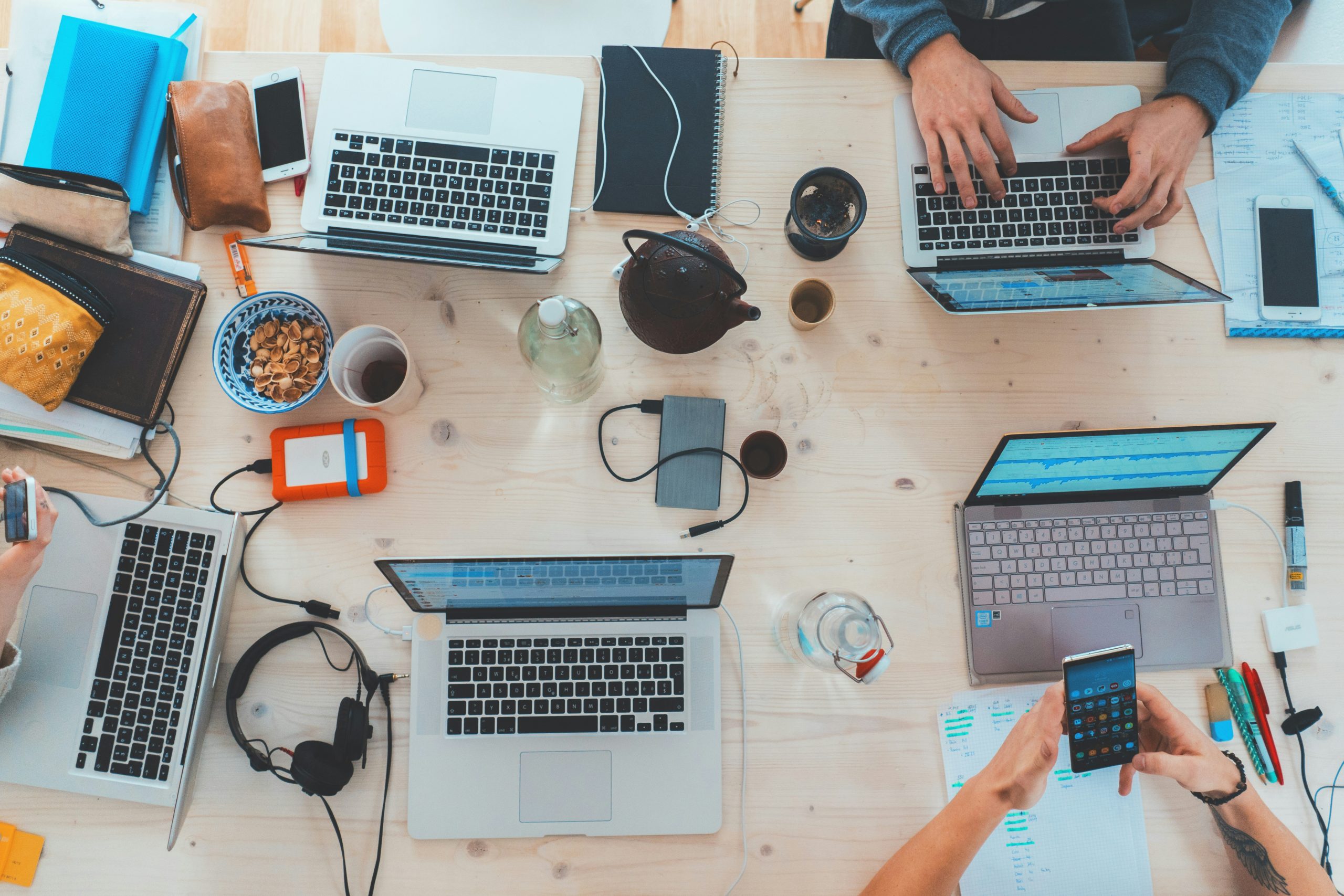 Marketing team collaborating around a table with laptops while planning a digital campaign